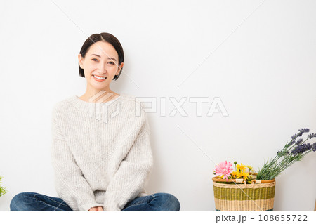 壁にもたれかかって座る若い女性　ライフスタイルイメージ 108655722