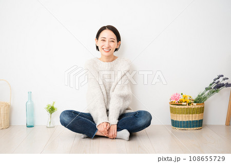 壁にもたれかかって座る若い女性　ライフスタイルイメージ 108655729