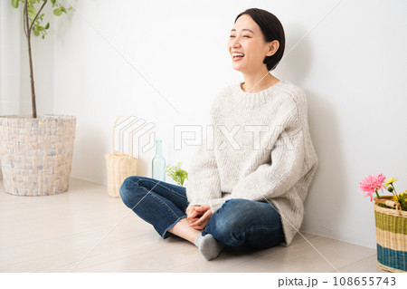 壁にもたれかかって座る若い女性　ライフスタイルイメージ 108655743