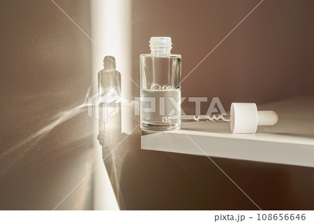 A transparent bottle of serum under the morning sun. 108656646
