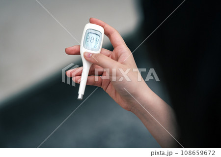 発熱して体温を計る女性 108659672