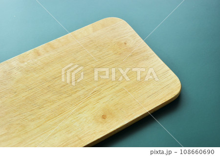 brown wooden cutting board on green background, equipment for cooking in the kitchen brown wooden cutting board on green background, equipment for cooking in the kitchen 108660690