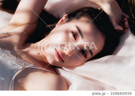 夕方に草原に寝転ぶ女性 ビューティーイメージ 夕方に草原に寝転ぶ女性 ビューティーイメージ 108660939