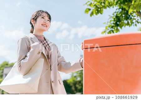郵便ポストに手紙を入れる女性（郵送・発送・申し込み） 108661929