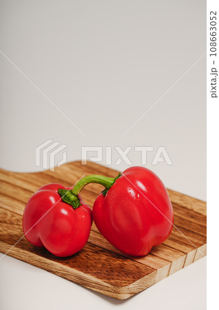 木製のまな板の上の赤いパプリカ 108663052