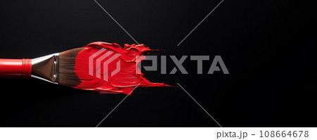 A red paintbrush dipped in paint against a dark black background A red paintbrush dipped in paint against a dark black background 108664678