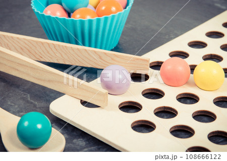 Colorful balls with spoon and tongs. Development of kids motor skills 108666122
