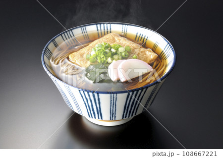 油揚げ、かまぼこ、ワカメ、葱が乗った熱々きつね蕎麦を黒背景で撮影 油揚げ、かまぼこ、ワカメ、葱が乗った熱々きつね蕎麦を黒背景で撮影 108667221