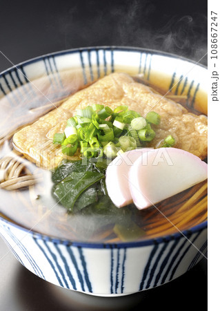 油揚げ、かまぼこ、ワカメ、葱が乗った熱々きつね蕎麦を黒背景で撮影 油揚げ、かまぼこ、ワカメ、葱が乗った熱々きつね蕎麦を黒背景で撮影 108667247