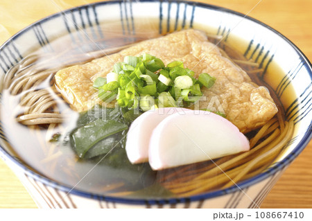 油揚げ、かまぼこ、ワカメ、葱が乗った熱々のきつね蕎麦 油揚げ、かまぼこ、ワカメ、葱が乗った熱々のきつね蕎麦 108667410