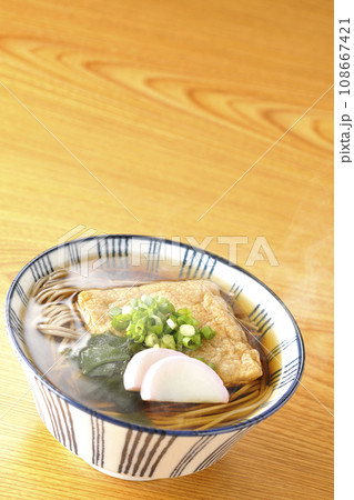 油揚げ、かまぼこ、ワカメ、葱が乗った熱々のきつね蕎麦 油揚げ、かまぼこ、ワカメ、葱が乗った熱々のきつね蕎麦 108667421