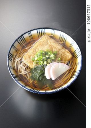 油揚げ、かまぼこ、ワカメ、葱が乗った熱々きつね蕎麦を黒背景で俯瞰撮影 油揚げ、かまぼこ、ワカメ、葱が乗った熱々きつね蕎麦を黒背景で俯瞰撮影 108667515