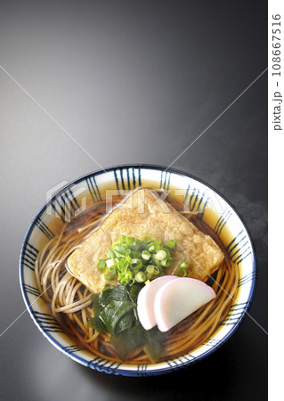 油揚げ、かまぼこ、ワカメ、葱が乗った熱々きつね蕎麦を黒背景で俯瞰撮影 油揚げ、かまぼこ、ワカメ、葱が乗った熱々きつね蕎麦を黒背景で俯瞰撮影 108667516