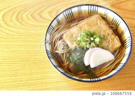油揚げ、かまぼこ、ワカメ、葱が乗った熱々のきつね蕎麦を俯瞰で撮影 油揚げ、かまぼこ、ワカメ、葱が乗った熱々のきつね蕎麦を俯瞰で撮影 108667558