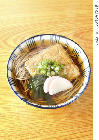 油揚げ、かまぼこ、ワカメ、葱が乗った熱々のきつね蕎麦を俯瞰で撮影 油揚げ、かまぼこ、ワカメ、葱が乗った熱々のきつね蕎麦を俯瞰で撮影 108667559
