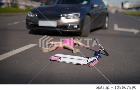 Girl lies on pavement after collision with cars on scooter 108667890