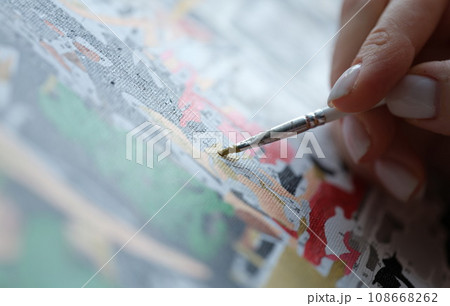 Woman paints picture with watercolors and holds brush 108668262