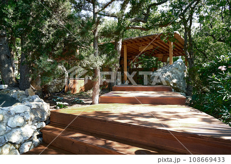 Empty wooden podium in the forest. Landscape of a valley of relict coniferous forests for demonstration or installation of your products. Front view Empty wooden podium in the forest. Landscape of a valley of relict coniferous forests for demonstration or installation of your products. Front view 108669433