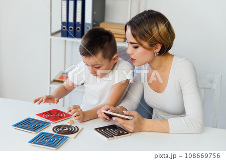 a boy with a psychologist in the office plays board games 108669756