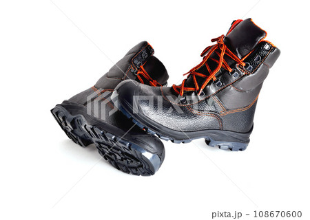 Black high boots with orange laces on a white background, off-road shoes, isolate, close-up 108670600