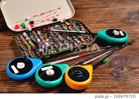 box with baits and fishing rods for winter fishing on a brown wooden background box with baits and fishing rods for winter fishing on a brown wooden background 108670720