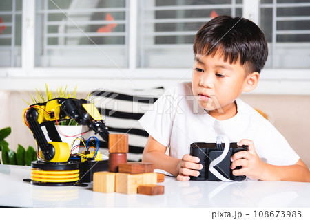 Happy Asian little kid boy using remote control playing robotic machine arm for pick up wood block, Funny child learning successful getting lesson control robot arm, Technology science education Happy Asian little kid boy using remote control playing robotic machine arm for pick up wood block, Funny child learning successful getting lesson control robot arm, Technology science education 108673983