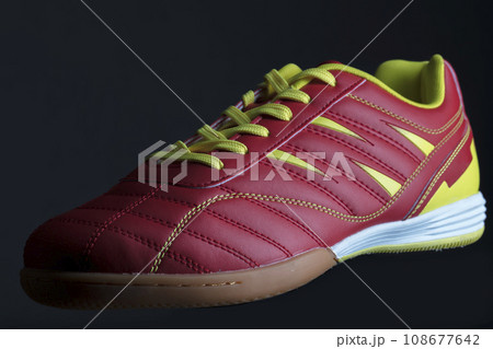 Red sneaker on a black background. Sport shoes 108677642