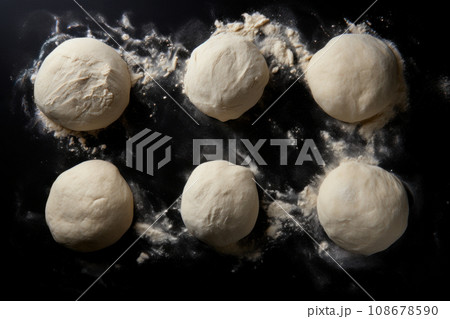 Raw dough balls and flour on black background, top view Raw dough balls and flour on black background, top view 108678590