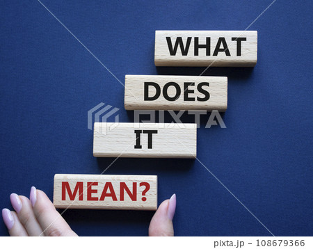 What does it mean symbol. Wooden blocks with words What does it mean. Beautiful deep blue background. Businessman hand. Business and What does it mean concept. Copy space. 108679366
