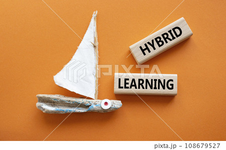 Hybrid learning symbol. Concept word Hybrid learning on wooden blocks with boat. Beautiful orange background. Business and Hybrid learning concept. Copy space Hybrid learning symbol. Concept word Hybrid learning on wooden blocks with boat. Beautiful orange background. Business and Hybrid learning concept. Copy space 108679527