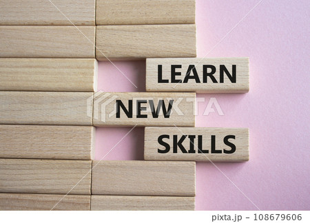 Learn new skills symbol. Concept words Learn new skills on wooden blocks. Beautiful pink background. Business and Learn new skills concept. Copy space. 108679606
