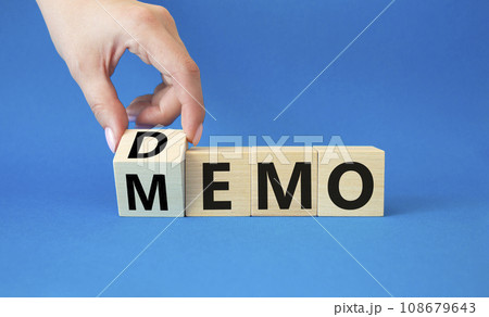 Demo and Memo symbol. Businessman hand turns wooden cube and changes word Memo to Demo. Beautiful blue background. Business and Demo and Memo concept. Copy space. 108679643