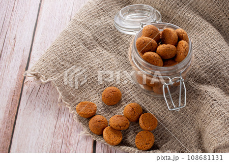 Pepernoten cookies in glass jar on sackcloth. Traditional sweets for St. Nicholas Day 108681131