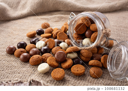 Pepernoten cookies in glass jar on sackcloth. Traditional sweets for St. Nicholas Day 108681132