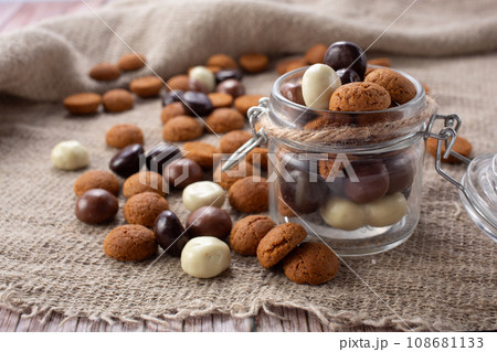 Pepernoten cookies in glass jar on sackcloth. Traditional sweets for St. Nicholas Day 108681133