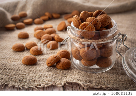 Pepernoten cookies in glass jar on sackcloth. Traditional sweets for St. Nicholas Day 108681135