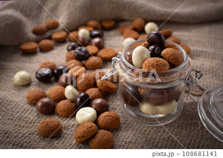 Pepernoten cookies in glass jar on sackcloth. Traditional sweets for St. Nicholas Day 108681141