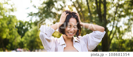 People and emotions concept. Happy asian woman laughing and smiling, posing on summer day in park People and emotions concept. Happy asian woman laughing and smiling, posing on summer day in park 108681354