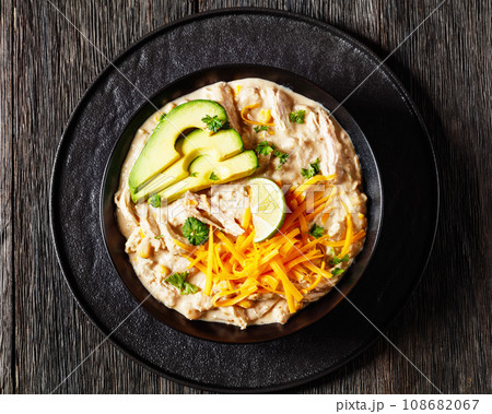 white chicken chili with cheese, avocado in bowl 108682067