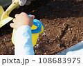 プランターにじょうろで水をあげる子供の手、縦長 108683975