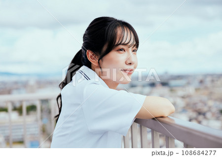 屋上で空を見上げる看護師 108684277