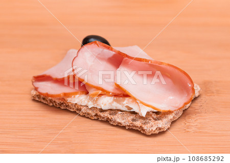 Whole Grain Crispbread with Ham, Cream Cheese and Olives Whole Grain Crispbread with Ham, Cream Cheese and Olives 108685292