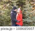 Happy woman and man hugging at Christmas Market in front of Christmas tree. 108685607