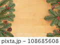Christmas flat lay of green fir branches, red berries and brown cones on wooden background. 108685608