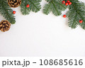 Christmas background. Green branches with red berries and brown cones. 108685616