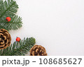 Christmas background of green branches with small red berries and brown cones. 108685627