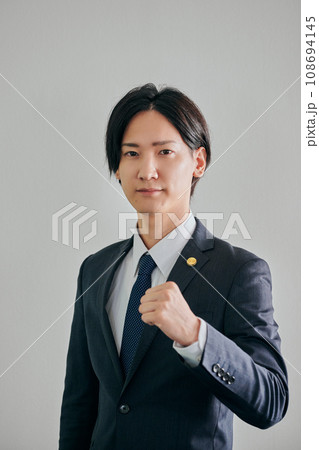 白バックを背景にガッツポーズをする男性弁護士 白バックを背景にガッツポーズをする男性弁護士 108694145