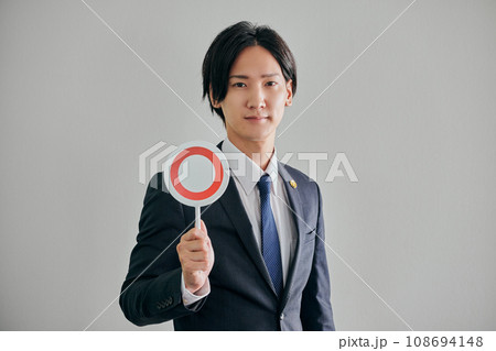 白バックを背景にまるの判定をする男性弁護士 108694148