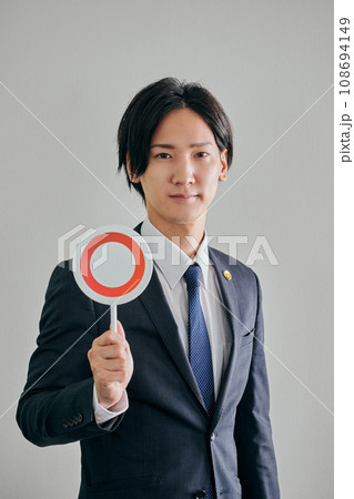 白バックを背景にまるの判定をする男性弁護士 白バックを背景にまるの判定をする男性弁護士 108694149