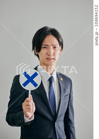 白バックを背景にばつの判定をする男性弁護士 白バックを背景にばつの判定をする男性弁護士 108694152